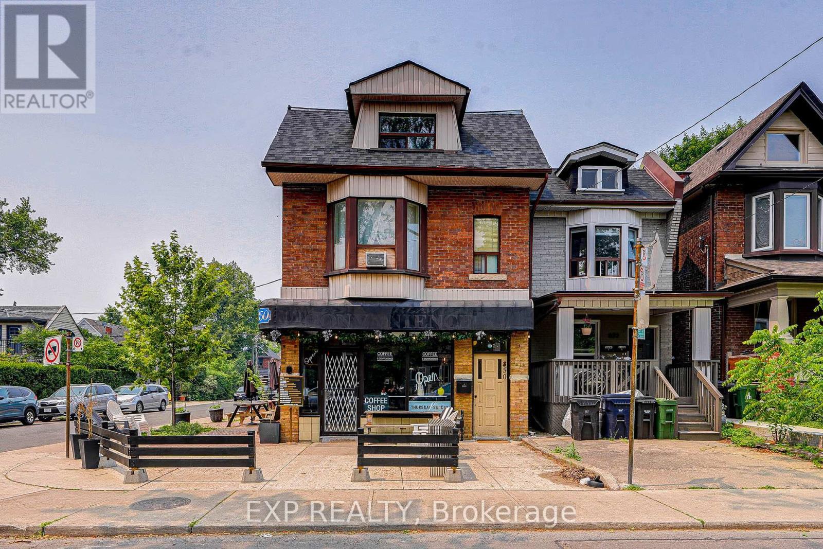 A real estate sign is displayed in front of a building.