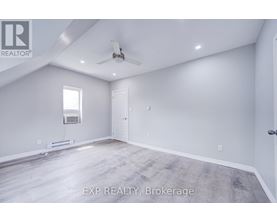 A spacious room with a ceiling fan and a window.