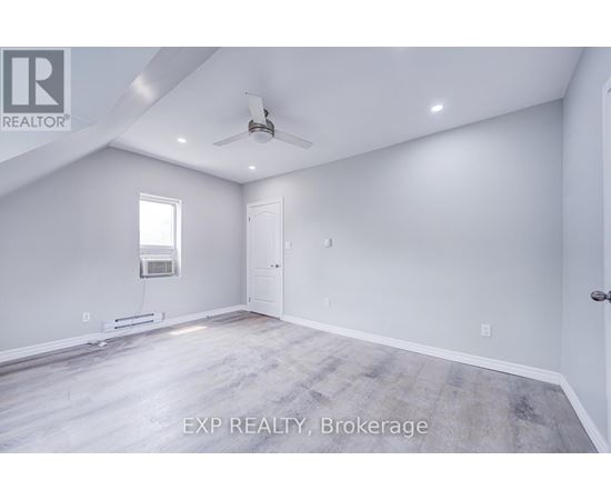 A spacious room with a ceiling fan and a window.