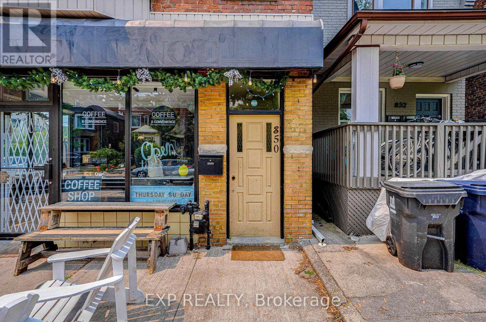 A coffee shop is located in a building with a brown door.
