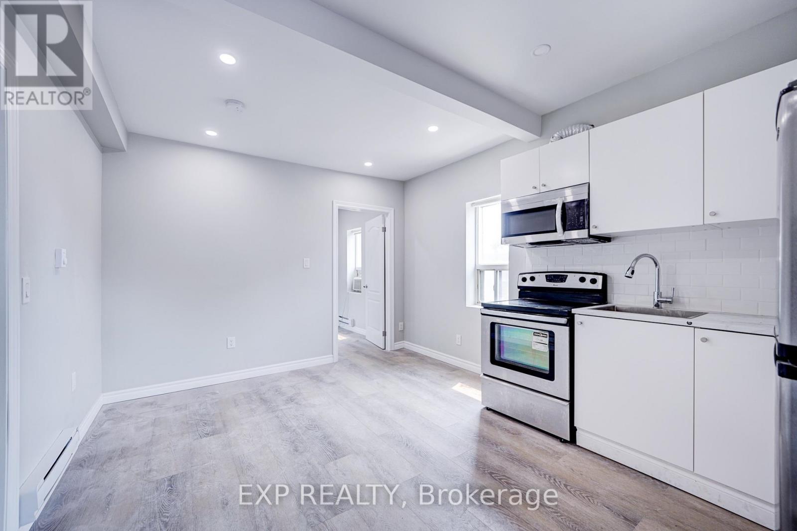 A kitchen with white cabinets and a stainless steel oven.