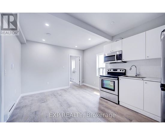 A kitchen with white cabinets and a stainless steel oven.