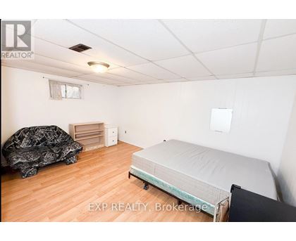 A bedroom with a bed, dresser, and a couch.
