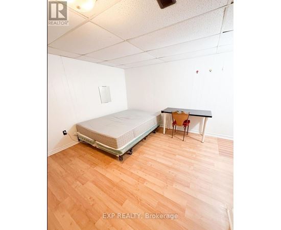 A bedroom with a bed, desk, and chair.
