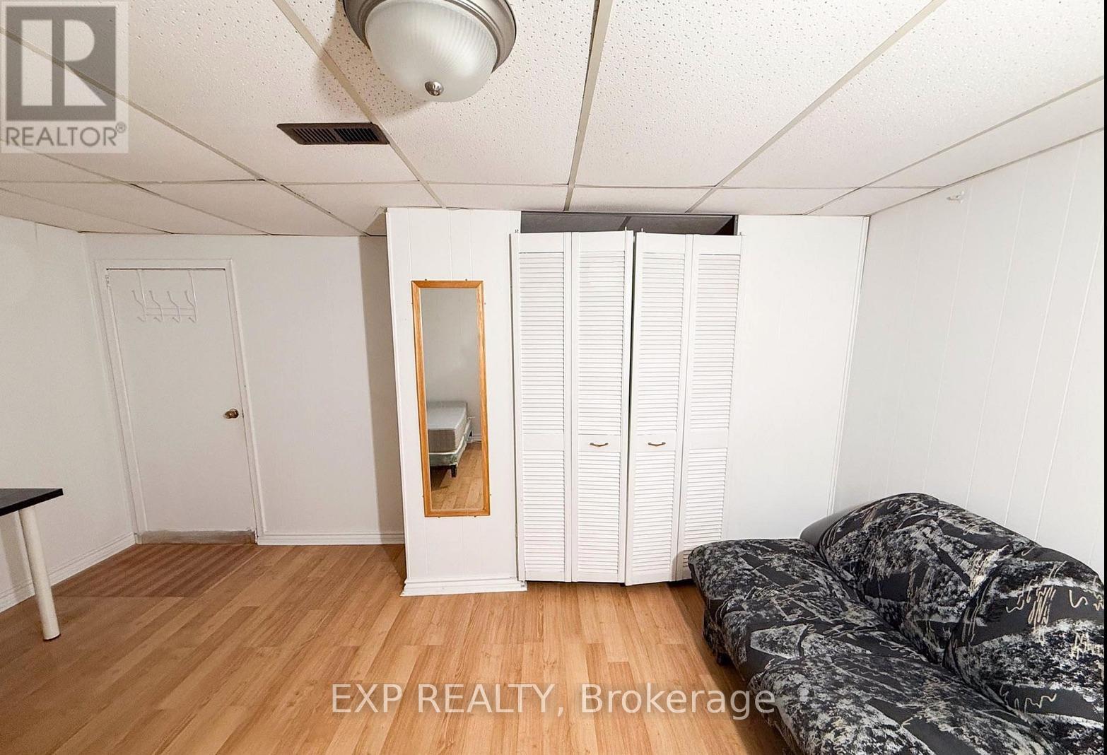 A room with a bed, a wardrobe, and a mirror.