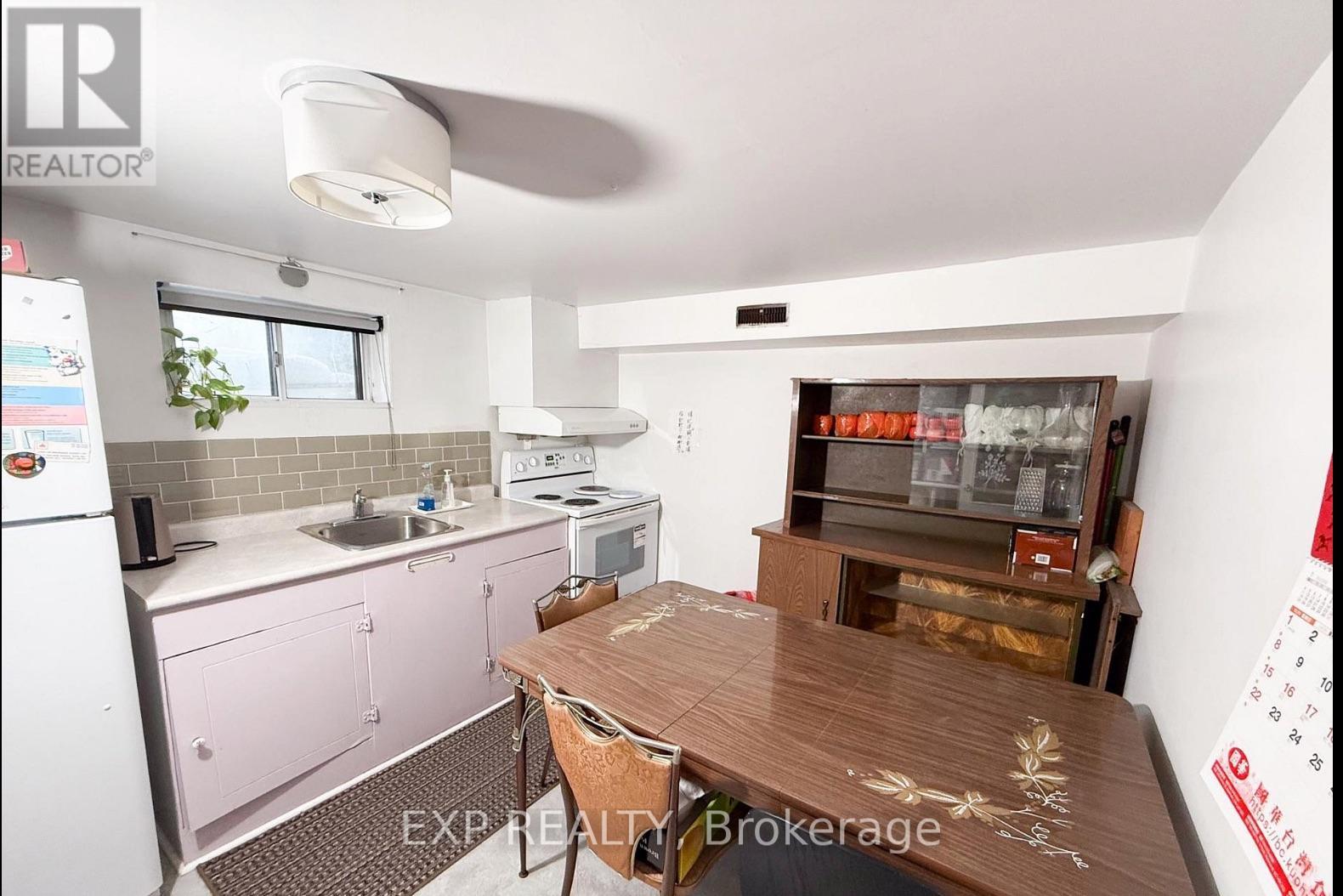 A kitchen with pink cabinets and a wooden table.