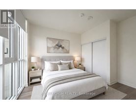 A bedroom with a large bed and a painting on the wall.