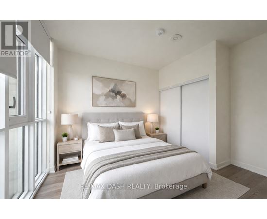 A bedroom with a large bed and a painting on the wall.