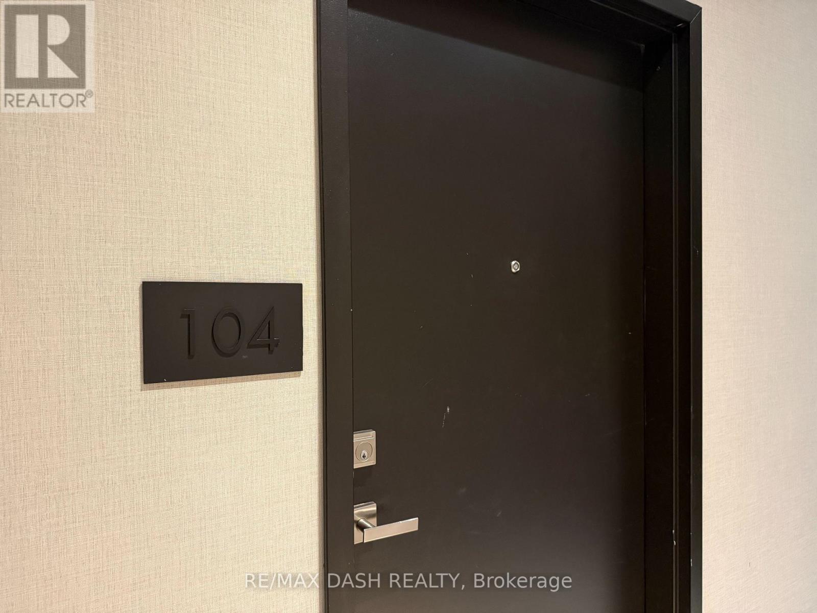A black door with a number plate on the wall.