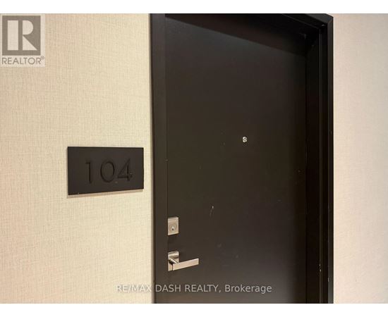 A black door with a number plate on the wall.