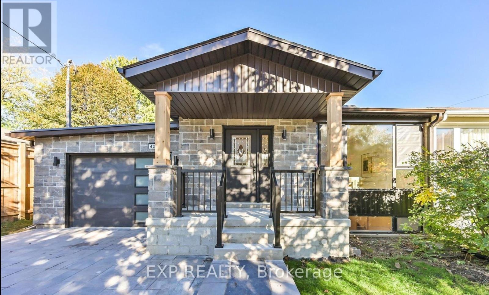 A modern house with a stone pillar in front.