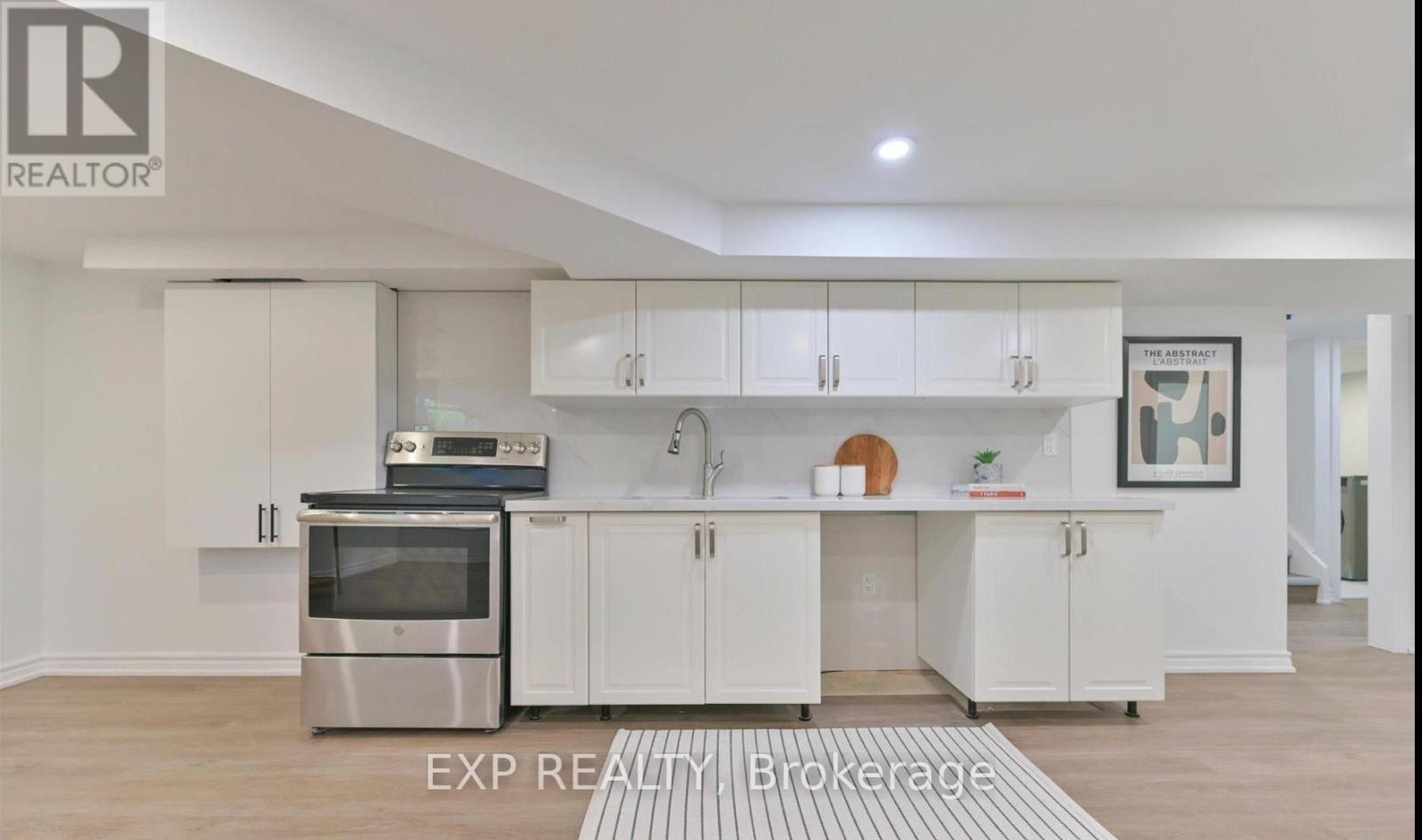 A modern kitchen with white cabinets and stainless steel appliances.