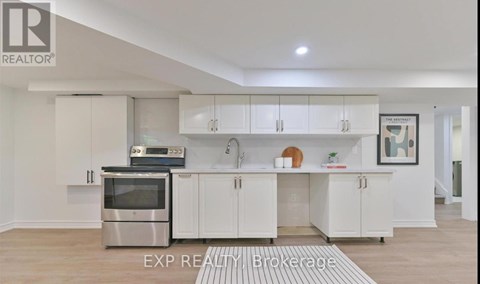 A modern kitchen with white cabinets and stainless steel appliances.