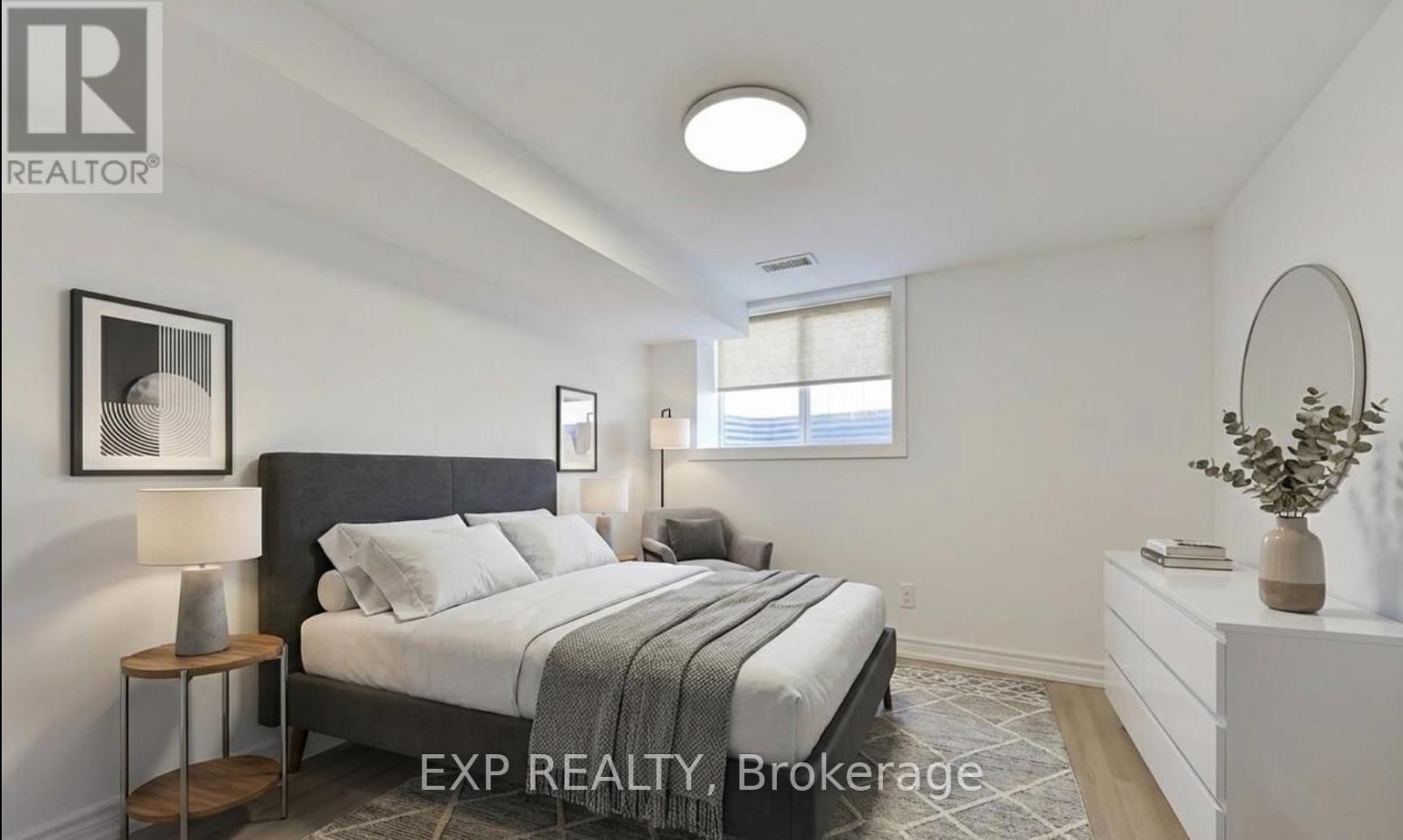 A bedroom with a bed, nightstands, and a plant.