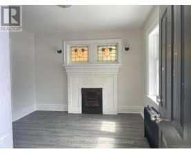 A white fireplace with a stained glass window above it.