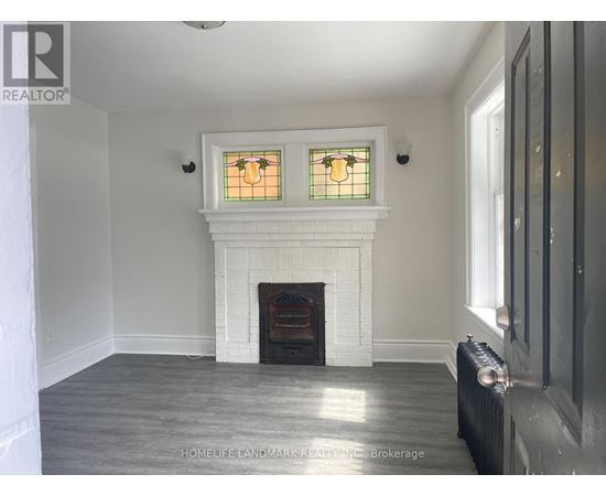 A white fireplace with a stained glass window above it.