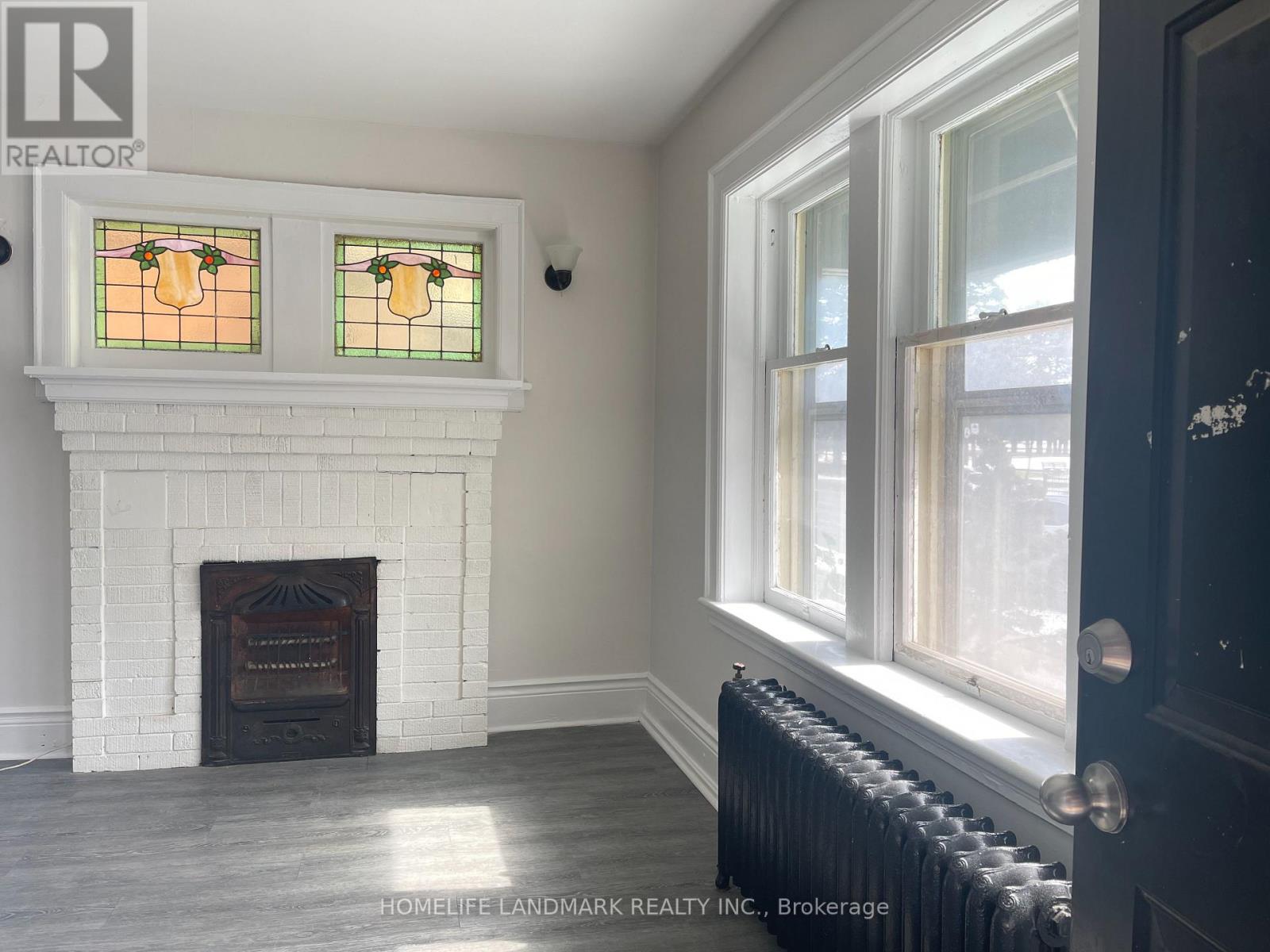 A room with a fireplace and a window with a stained glass design.