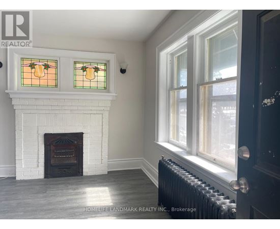 A room with a fireplace and a window with a stained glass design.