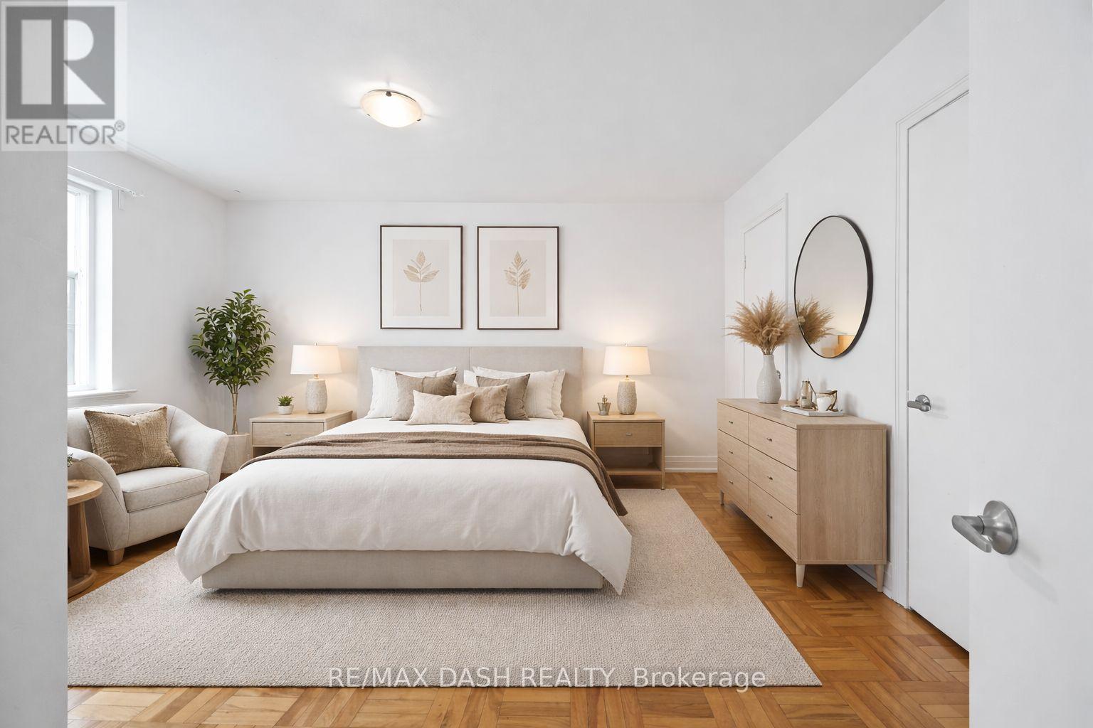 A bedroom with a large bed, a couch, and a dresser with a mirror.