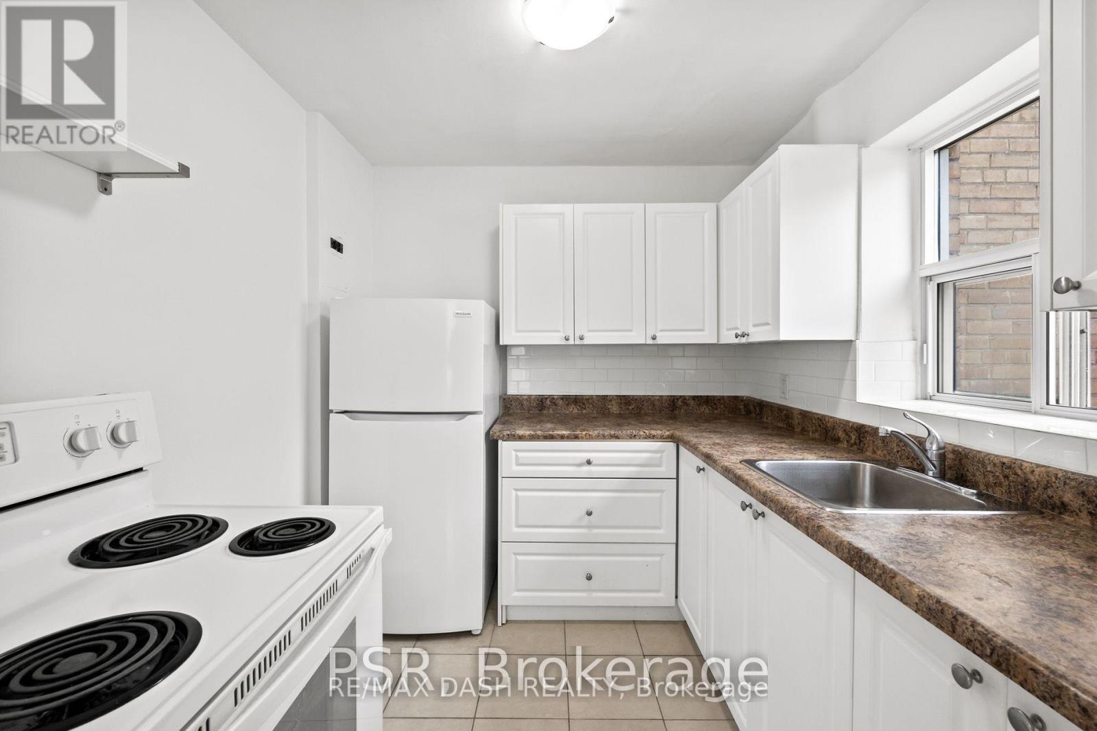 A kitchen with white appliances and cabinets.