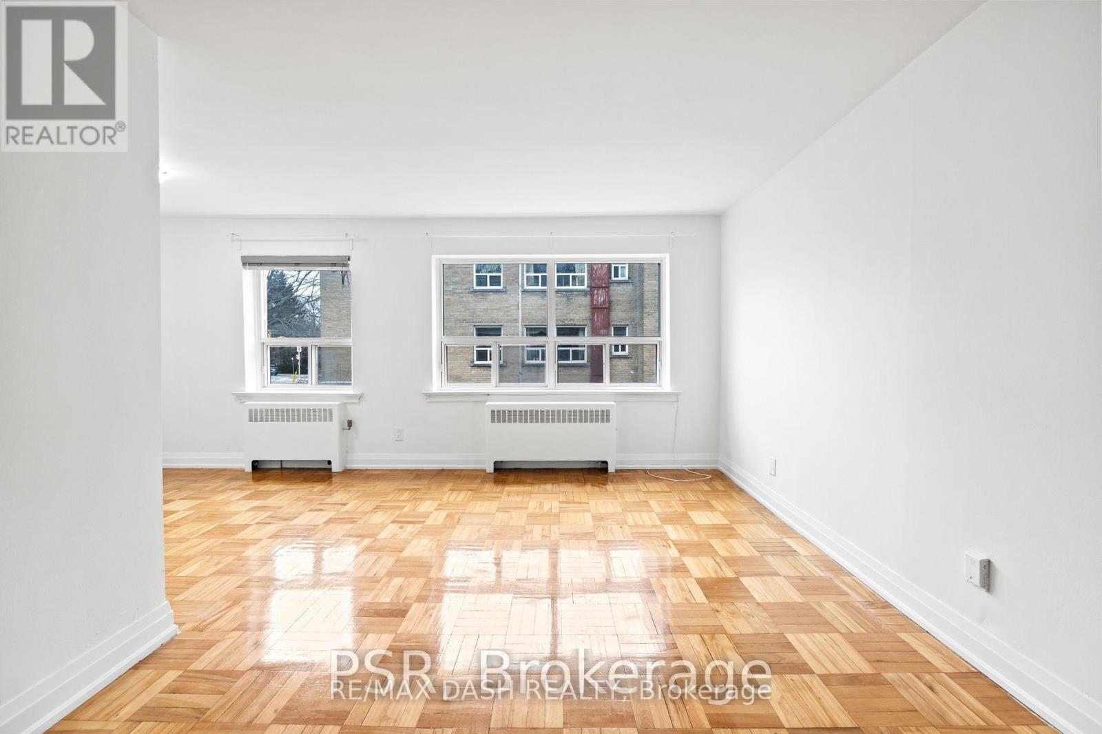 A room with a large window and a view of a building across the street.