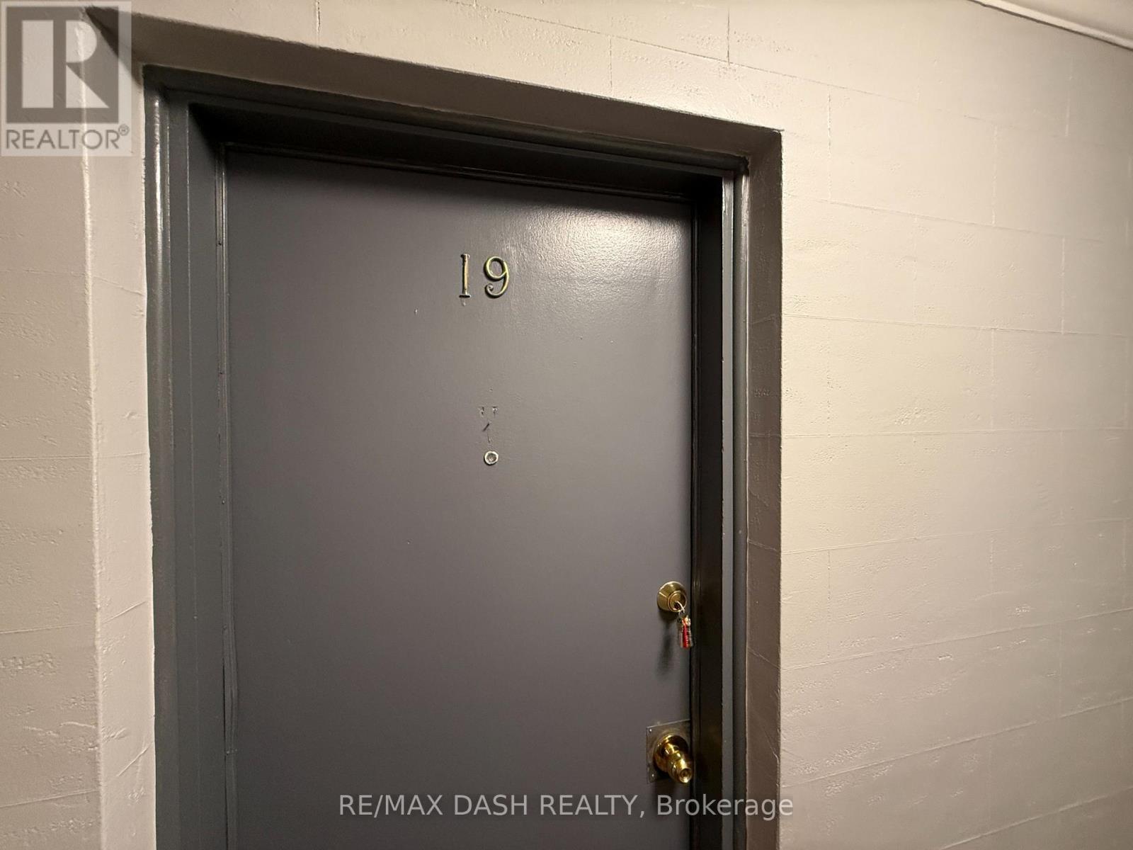 A door with the number 19 on it and a gold handle.