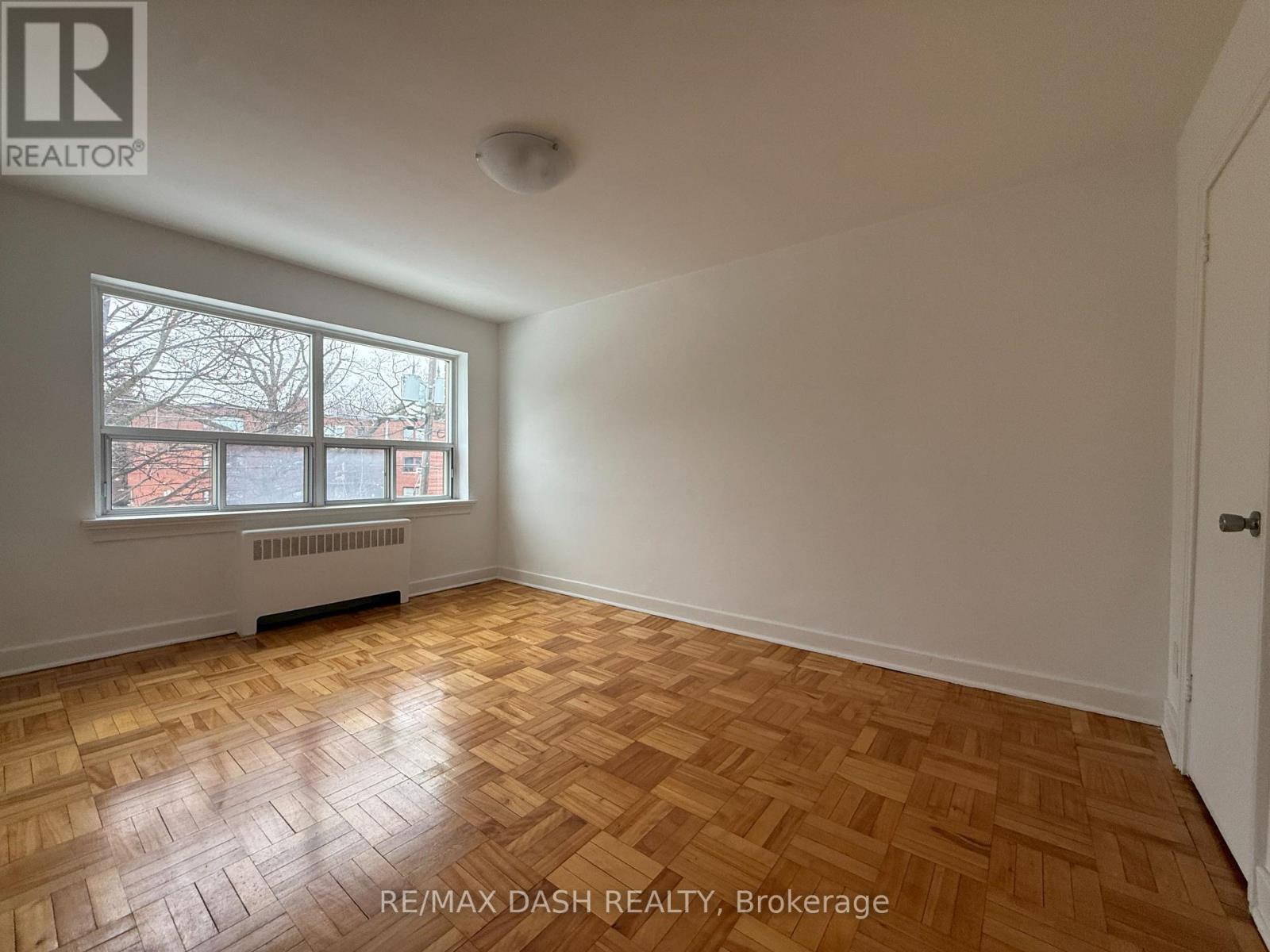 A room with a window and a radiator on the wall.