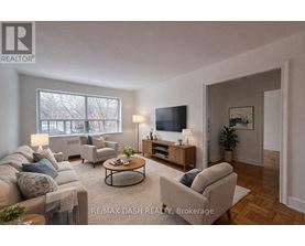 A well-lit living room with a couch, chair, and television.