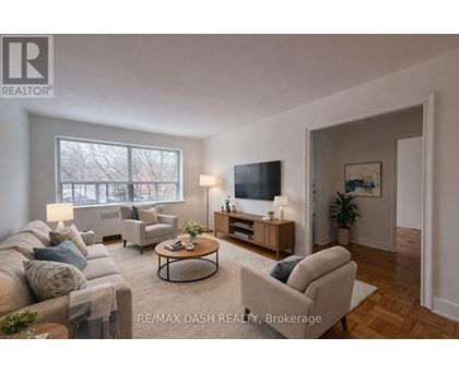 A well-lit living room with a couch, chair, and television.