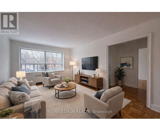 A well-lit living room with a couch, chair, and television.