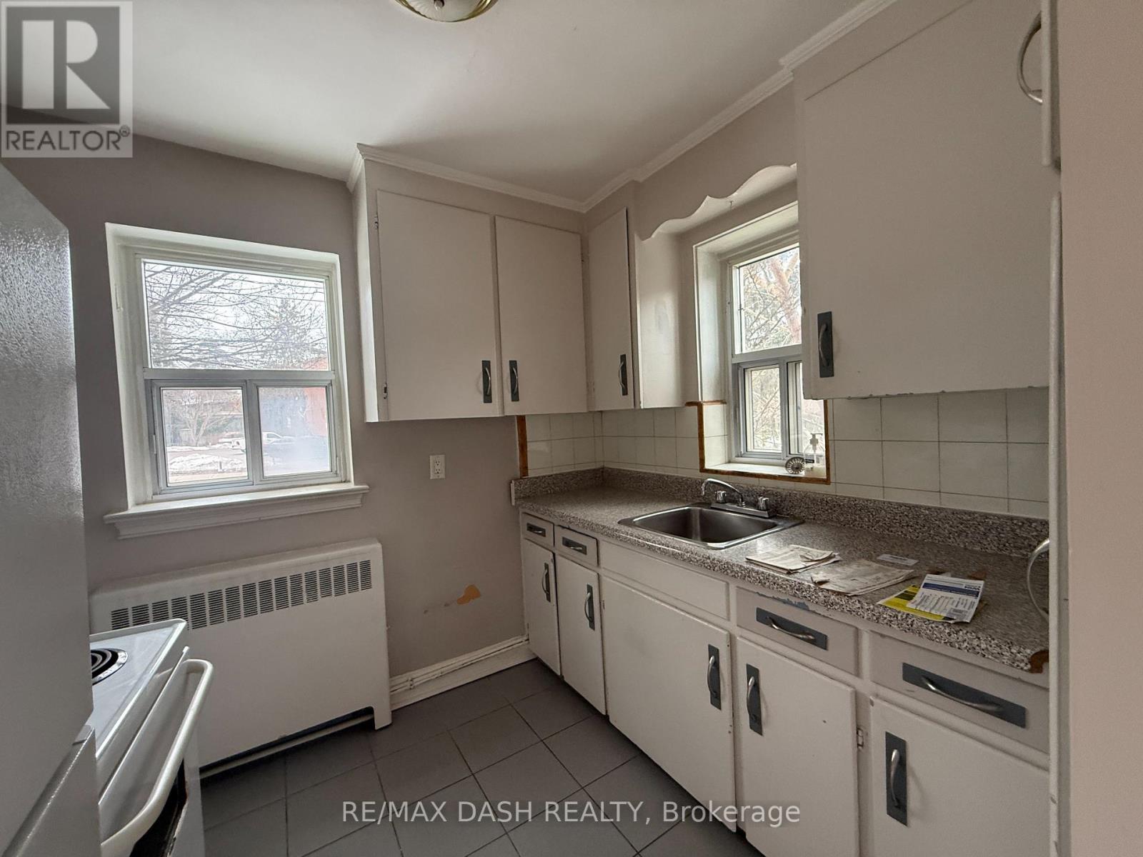A kitchen with white cabinets and a granite countertop.