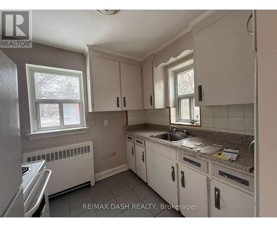 A kitchen with white cabinets and a granite countertop.