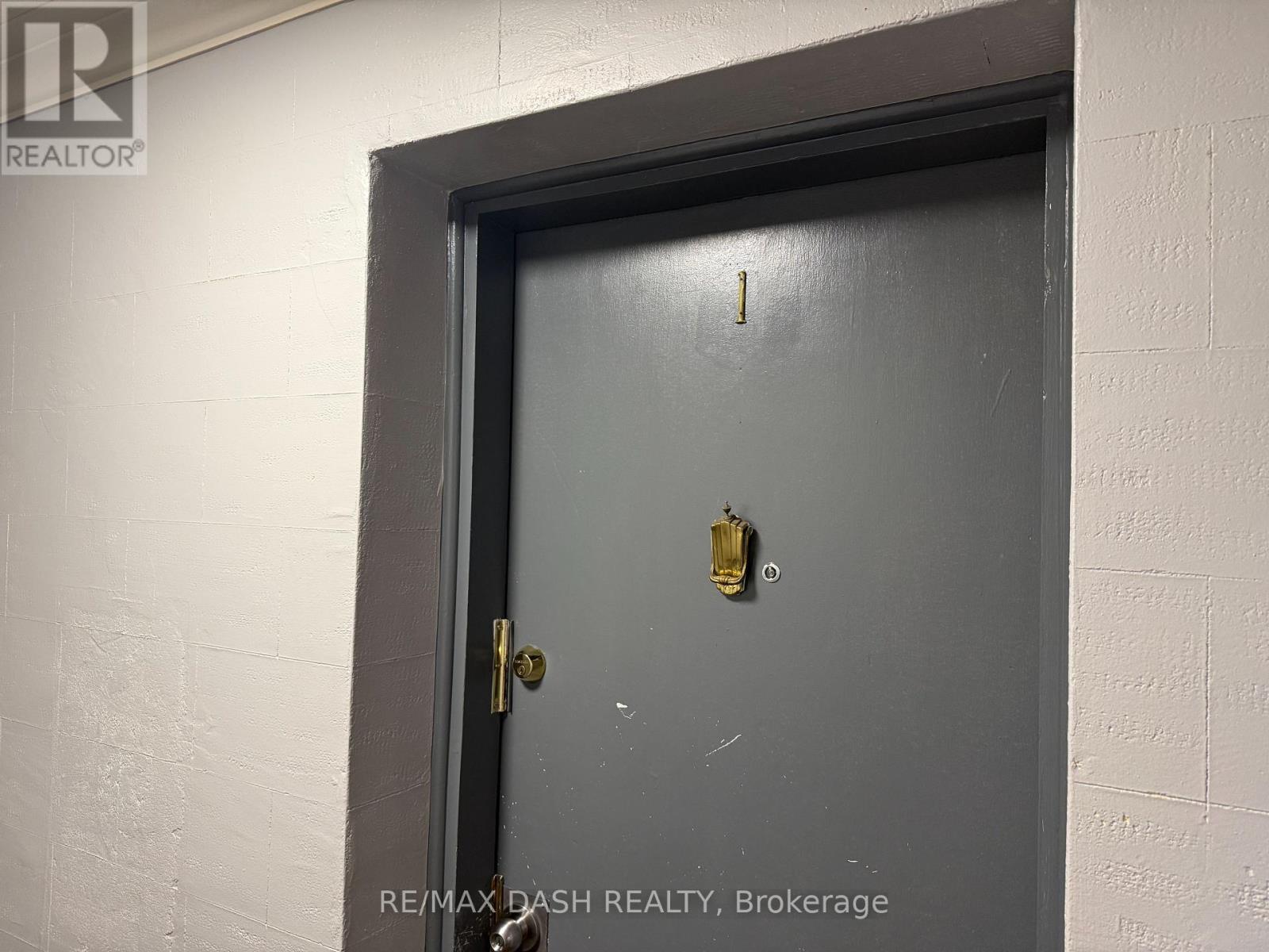 A door with a gold doorknob is in a white wall.