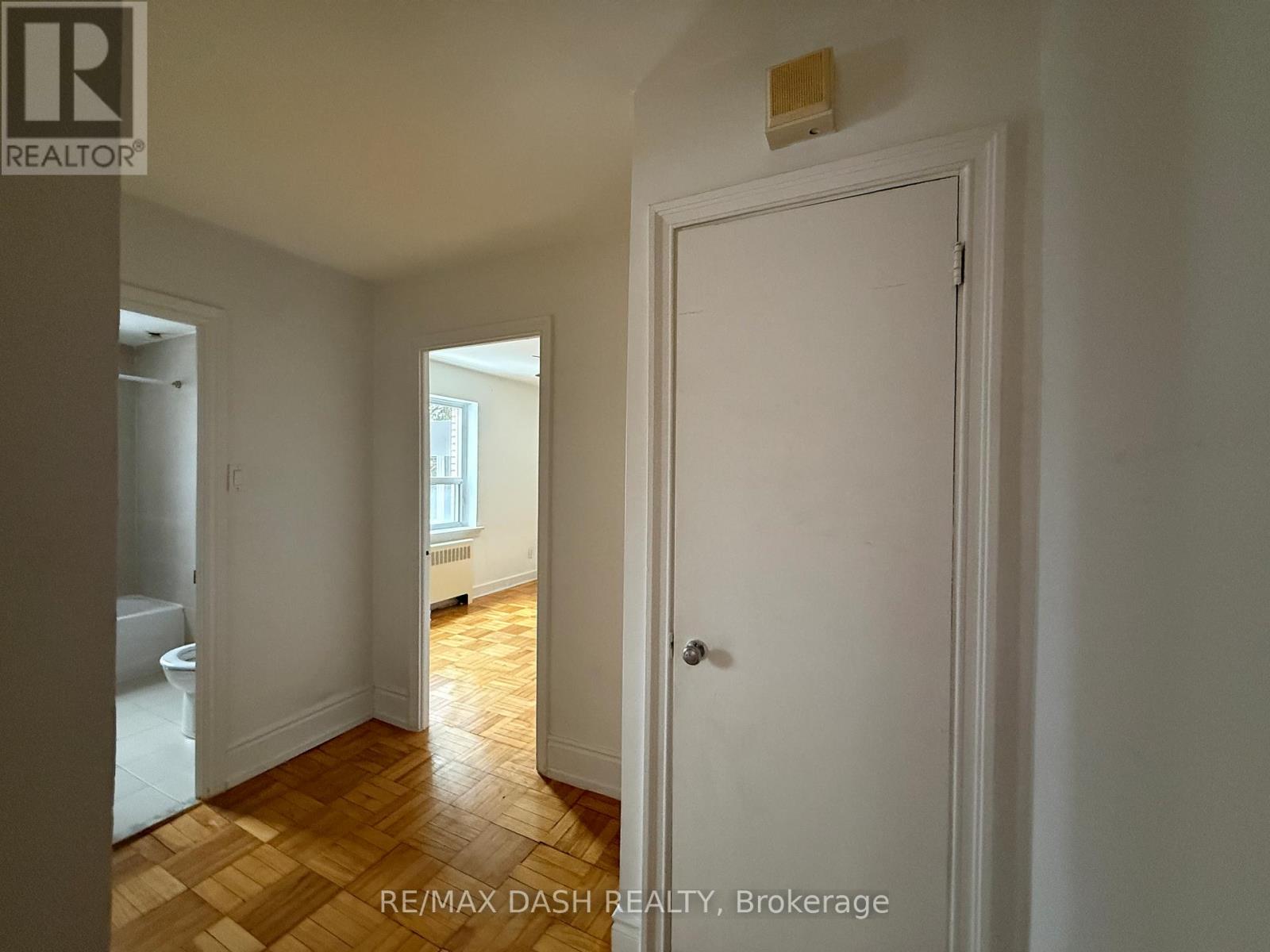 A white door is in a room with a wooden floor.