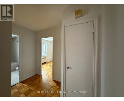 A white door is in a room with a wooden floor.