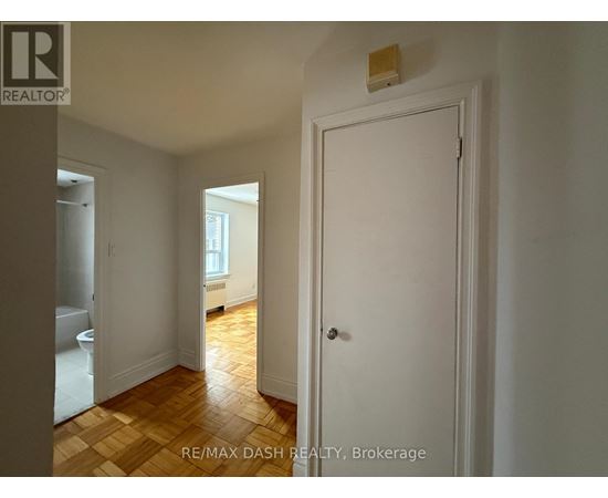 A white door is in a room with a wooden floor.