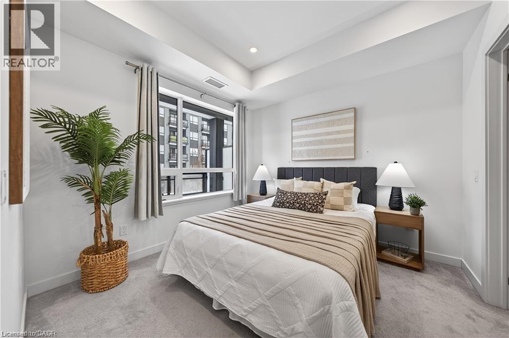 A bedroom with a large bed and a potted plant.