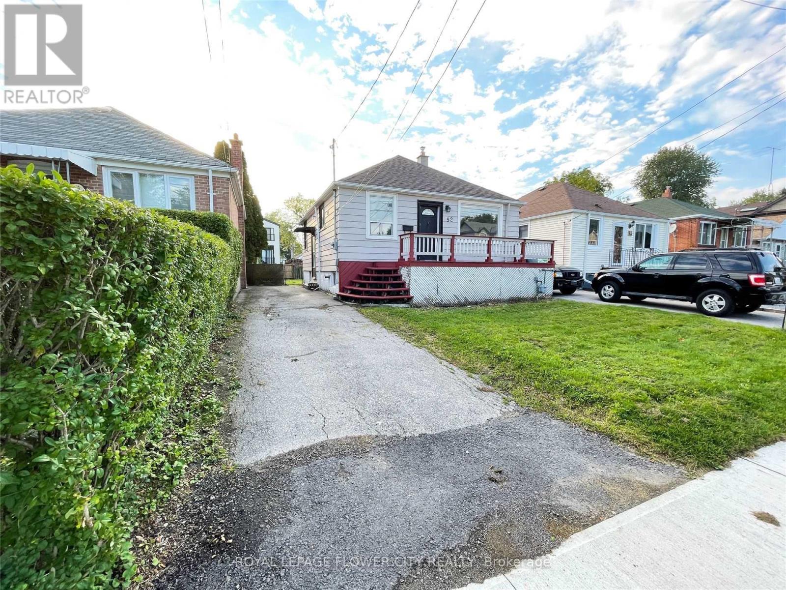 A residential street with houses and parked cars.