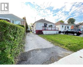 A residential street with houses and parked cars.
