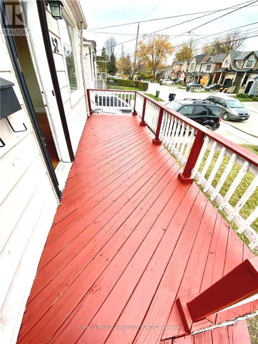 A red wooden deck with a white railing.