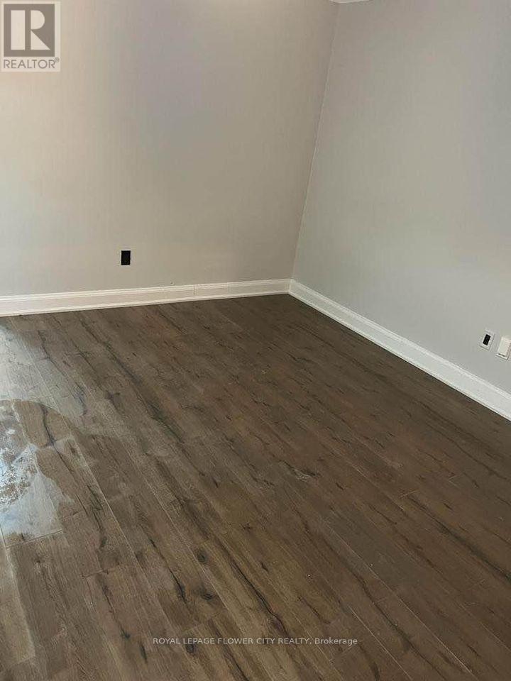 A room with wooden flooring and a white wall.