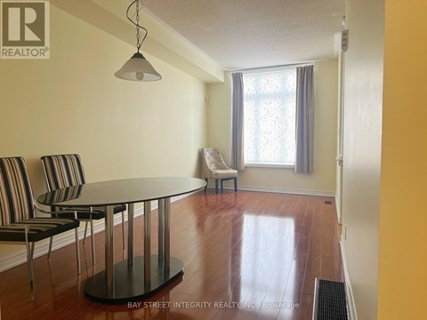 A living room with a glass table and striped chairs.