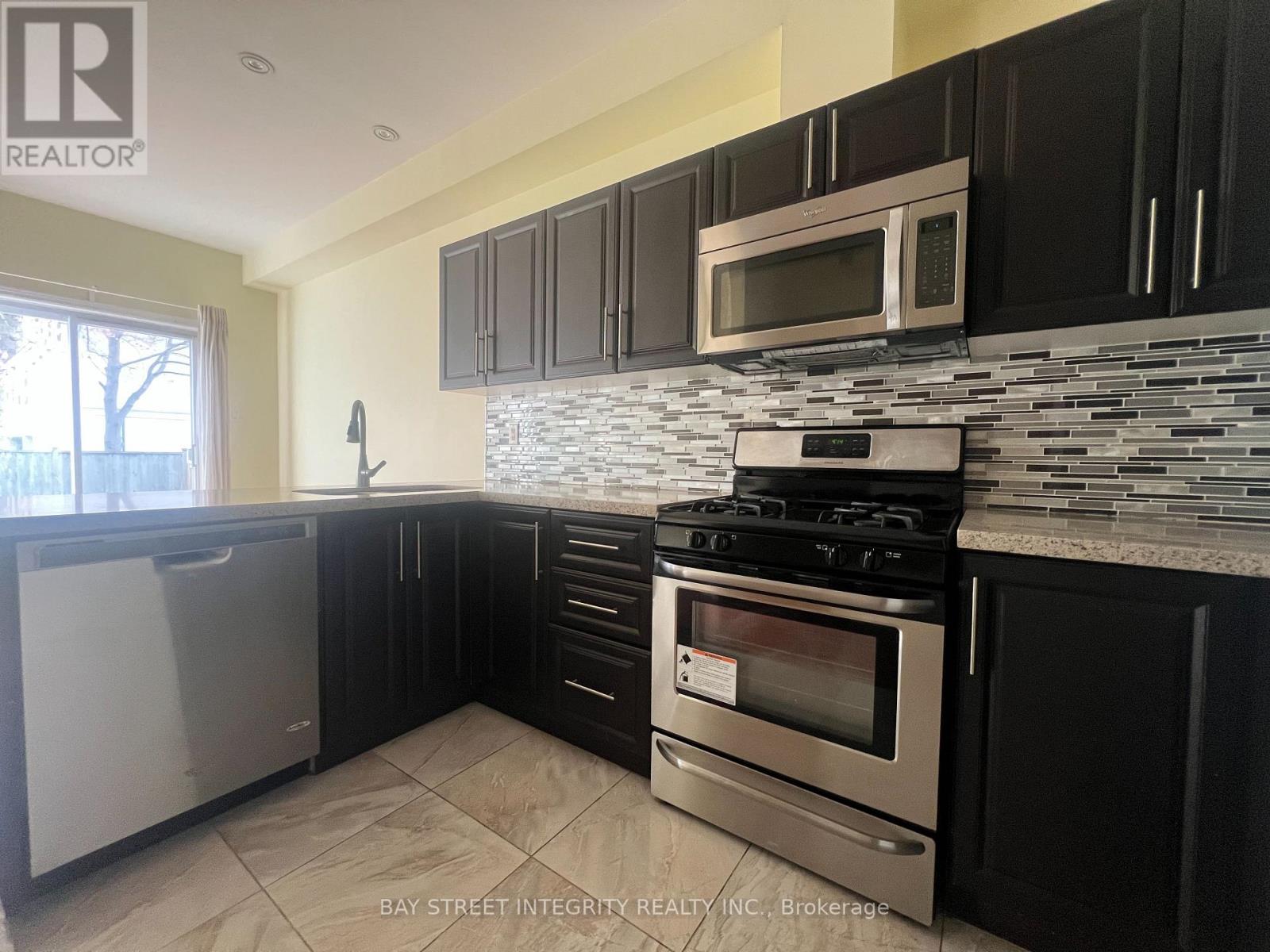 A kitchen with black cabinets and a stove top oven.