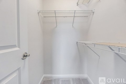 A white walk-in closet with shelves and a door.