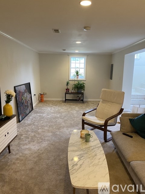 A living room with a couch, chair, and a table with candles on it.