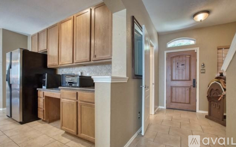A kitchen with wooden cabinets and a black refrigerator.