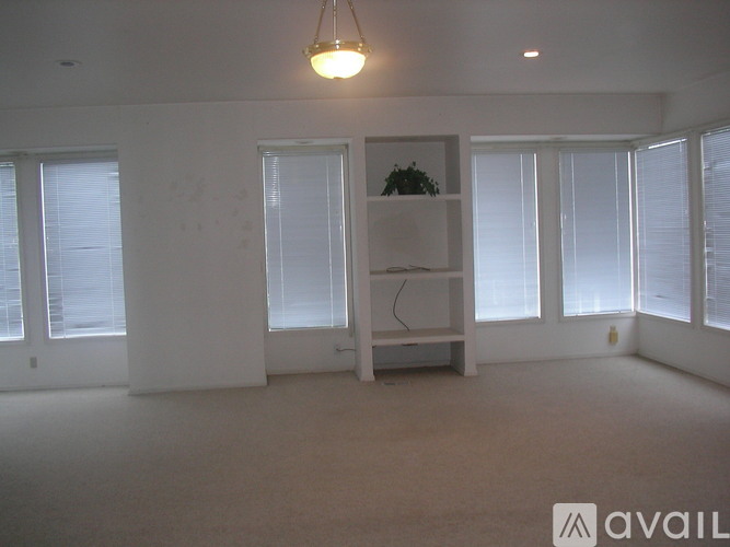 A room with a white wall and a hanging light fixture.