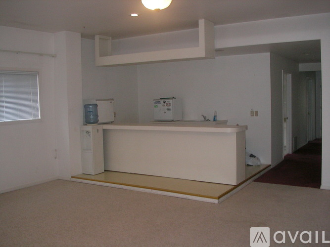 A white kitchen island with a countertop and a small fridge underneath it.