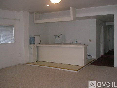 A white kitchen island with a countertop and a small fridge underneath it.