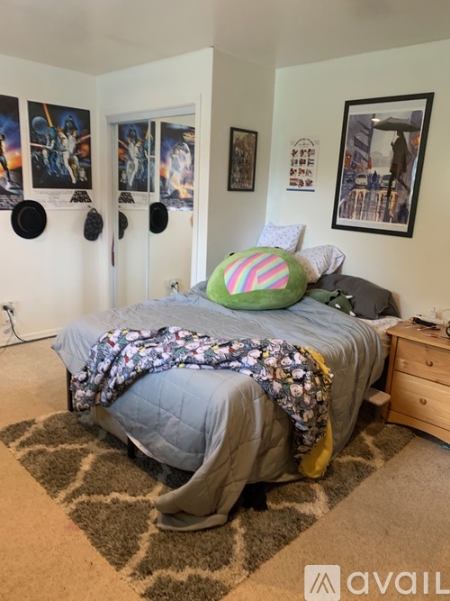 A bedroom with a bed, pillow, and pictures on the wall.